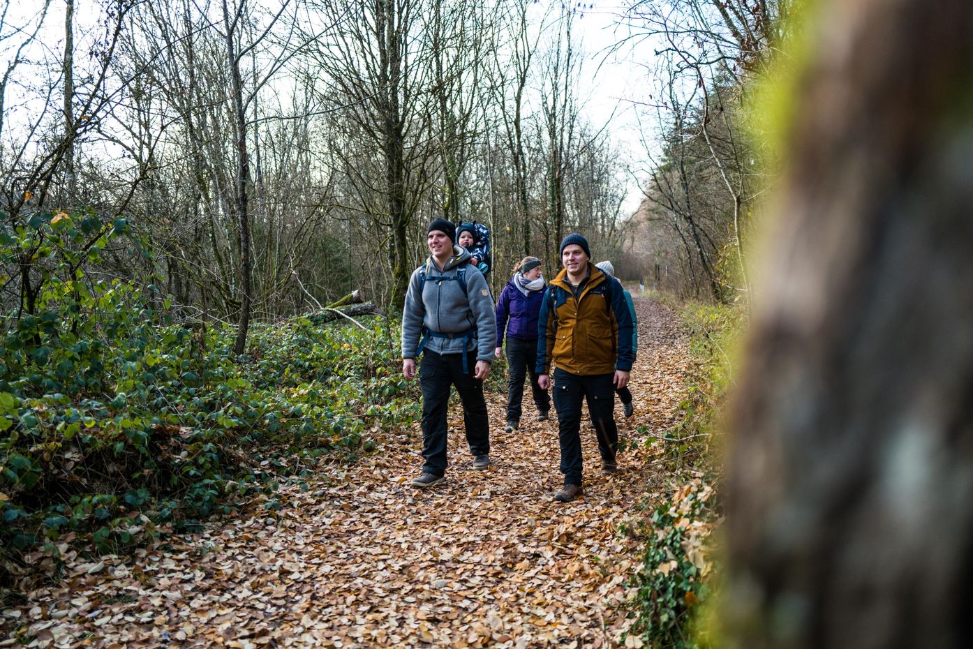 Un groupe de randonneurs sur un sentier forestier couvert de feuilles