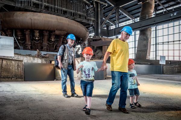 Eine Familie besichtigt den Hochofen und bestaunt die Halle unter dem Hochofen