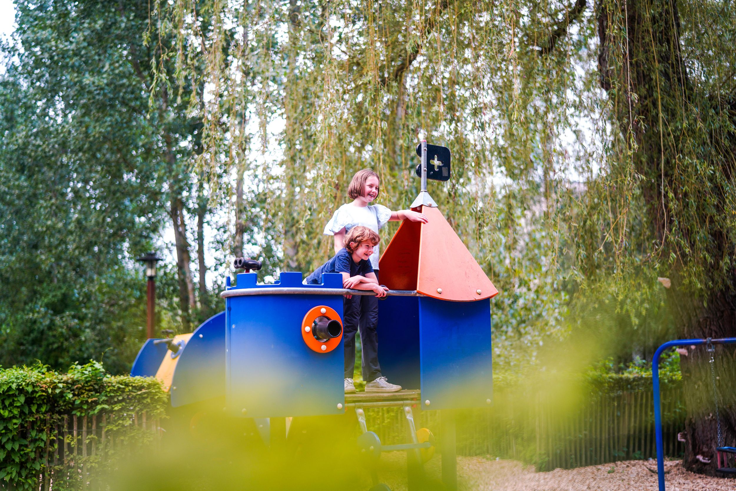 Une photo d'une famille sure une aire de jeux