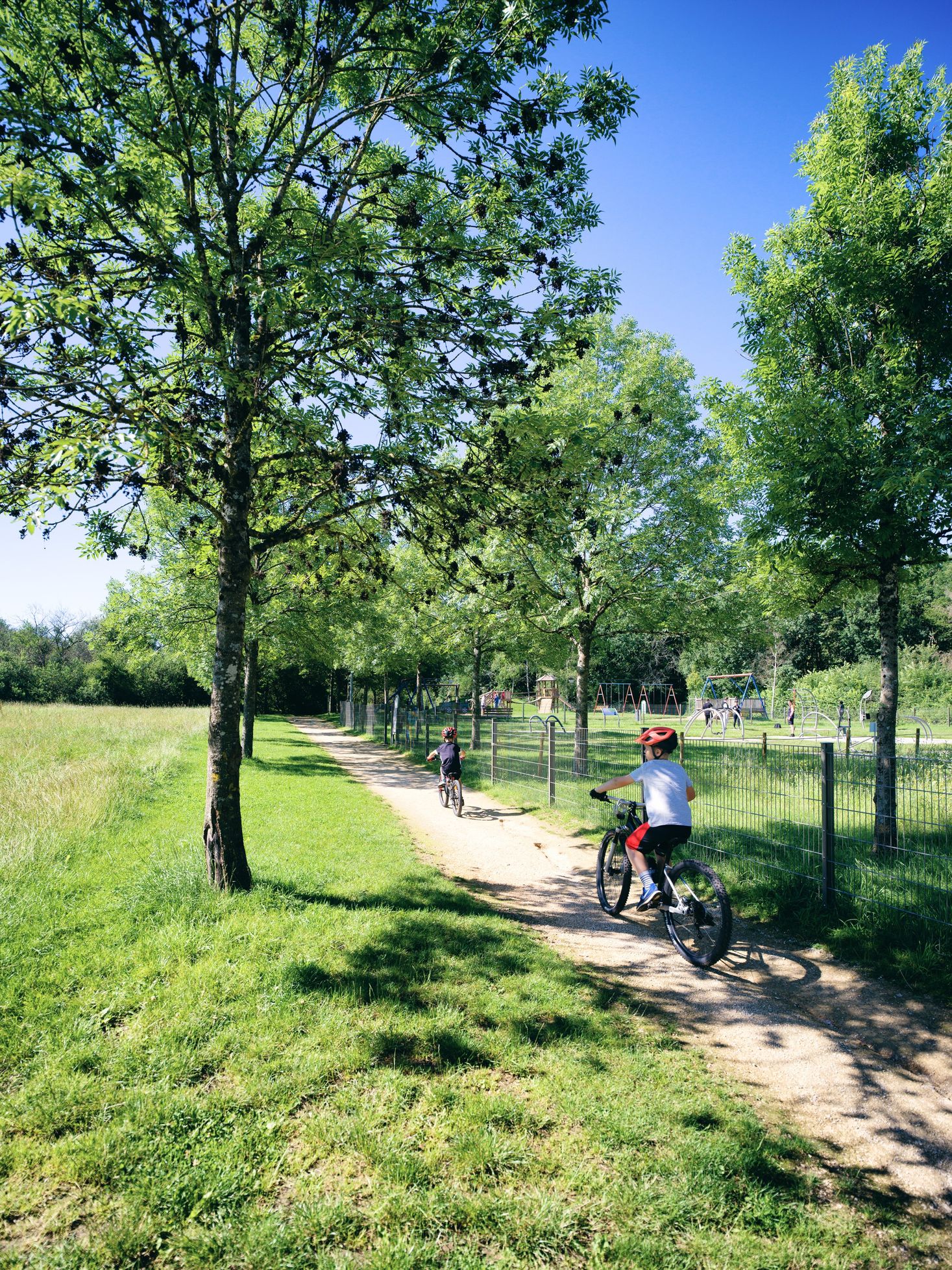 Deux enfants en VTT sur une piste cyclable étroite