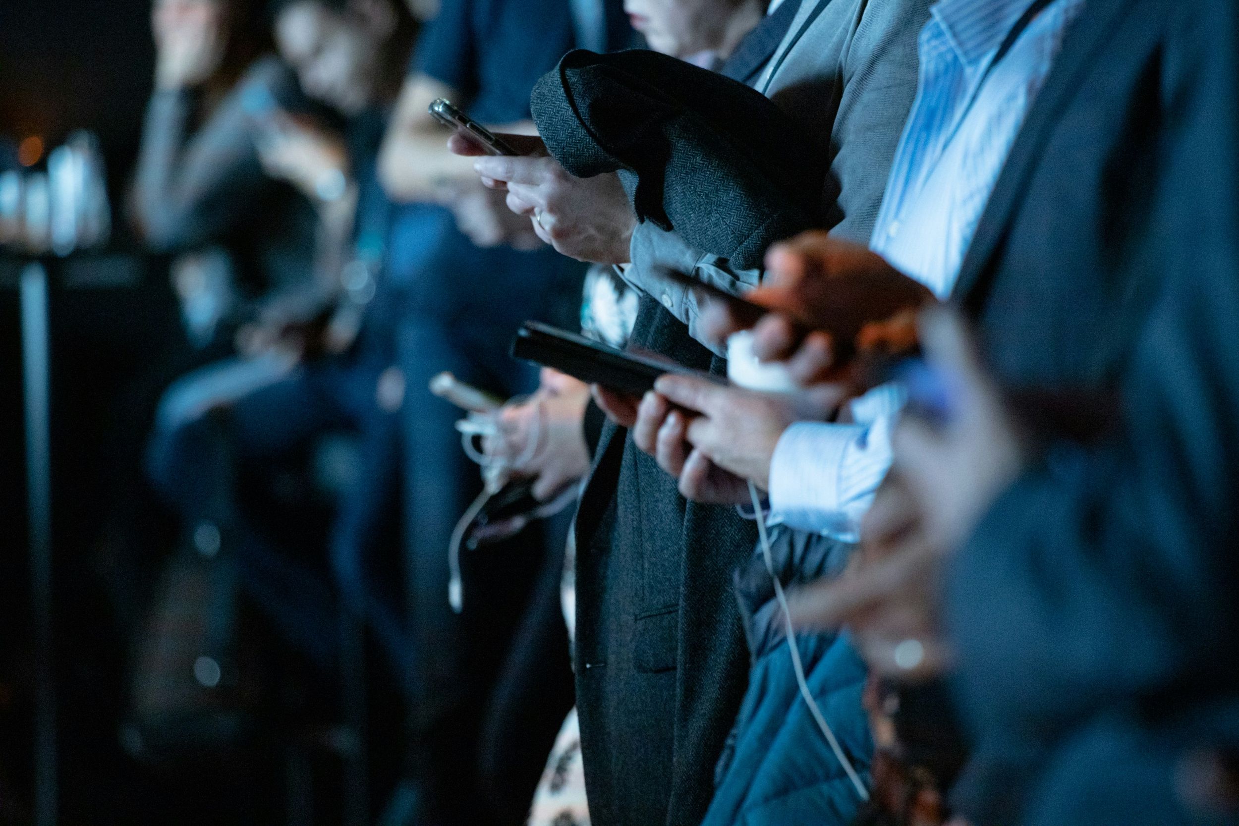 Ein Stockimage von mehreren Smartphone-Nutzern, die ihre Telefone betrachten
